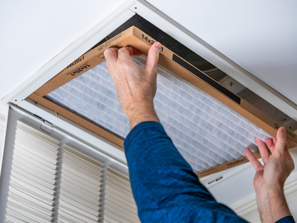 HVAC technician replacing a home air filter in Carson