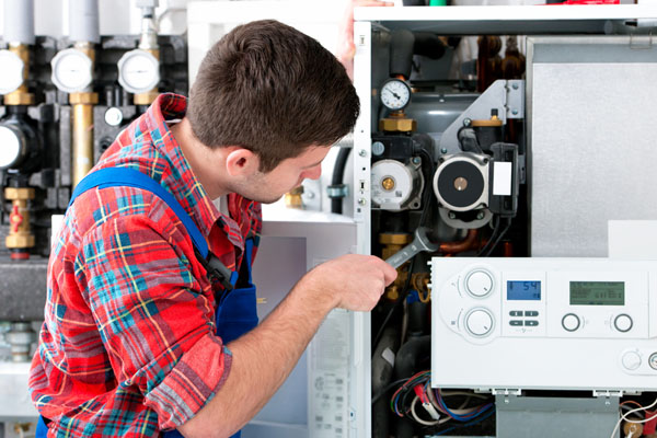 Heating technician repairing boiler controls in Carson