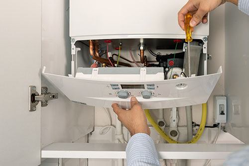 Heating technician repairing a residential boiler in Carson