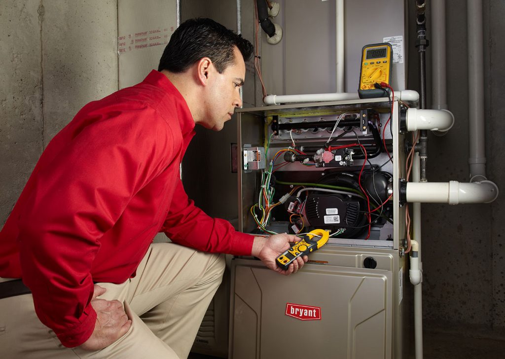 Heating technician diagnosing a furnace repair in Carson