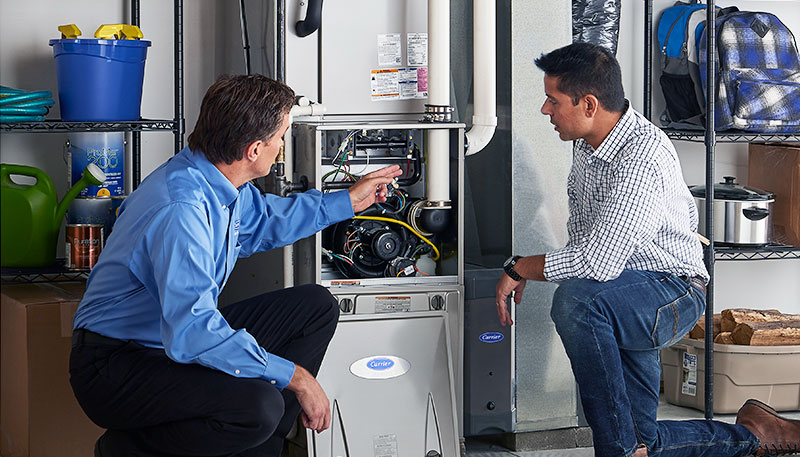 Technician evaluating a furnace for repair or replacement in Carson