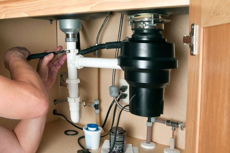 Plumber repairing a garbage disposal in Carson