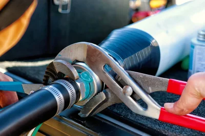 Technician repairing an industrial pipe connection in Carson