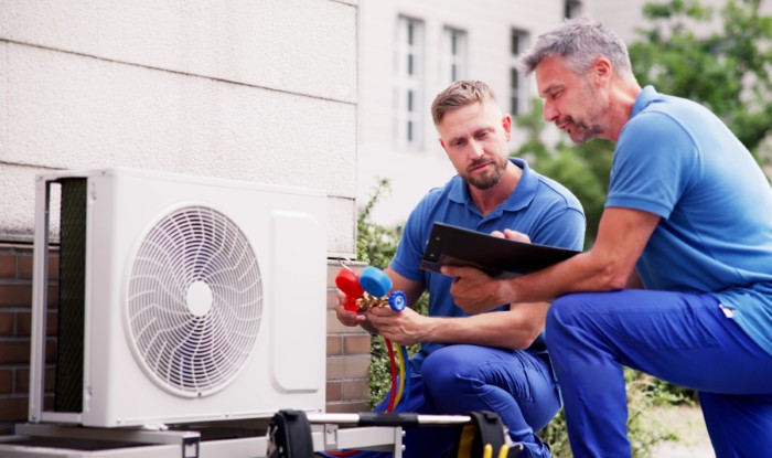 HVAC technicians installing an outdoor air conditioning unit in Carson
