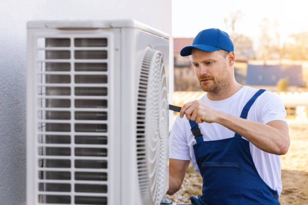 HVAC technician servicing an outdoor air conditioner in Carson