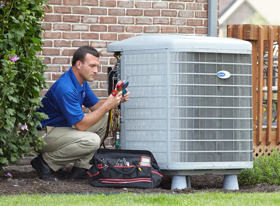 HVAC technician inspecting an outdoor AC unit in Carson